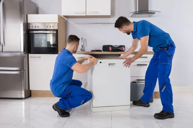 Movers wrapping furniture with protective padding.